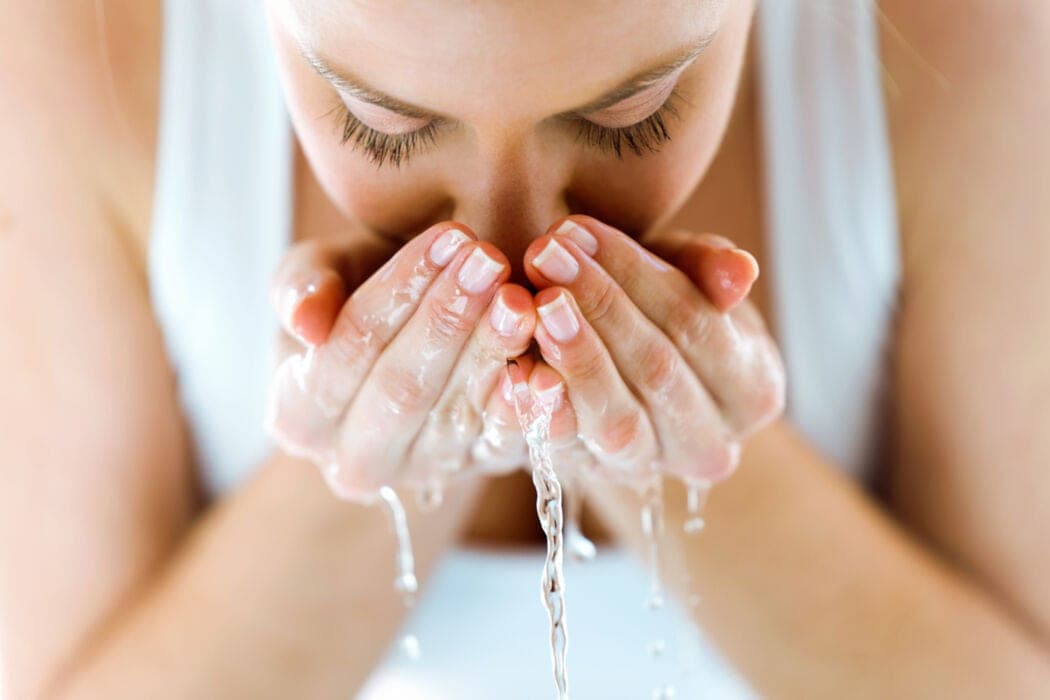 Gezicht reinigen met schone handen en water